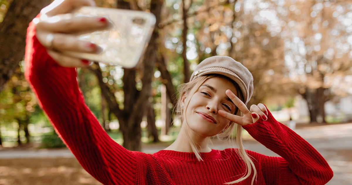Egy fiatal lány önarcképet, avagy szelfit készít a telefon kamerájával