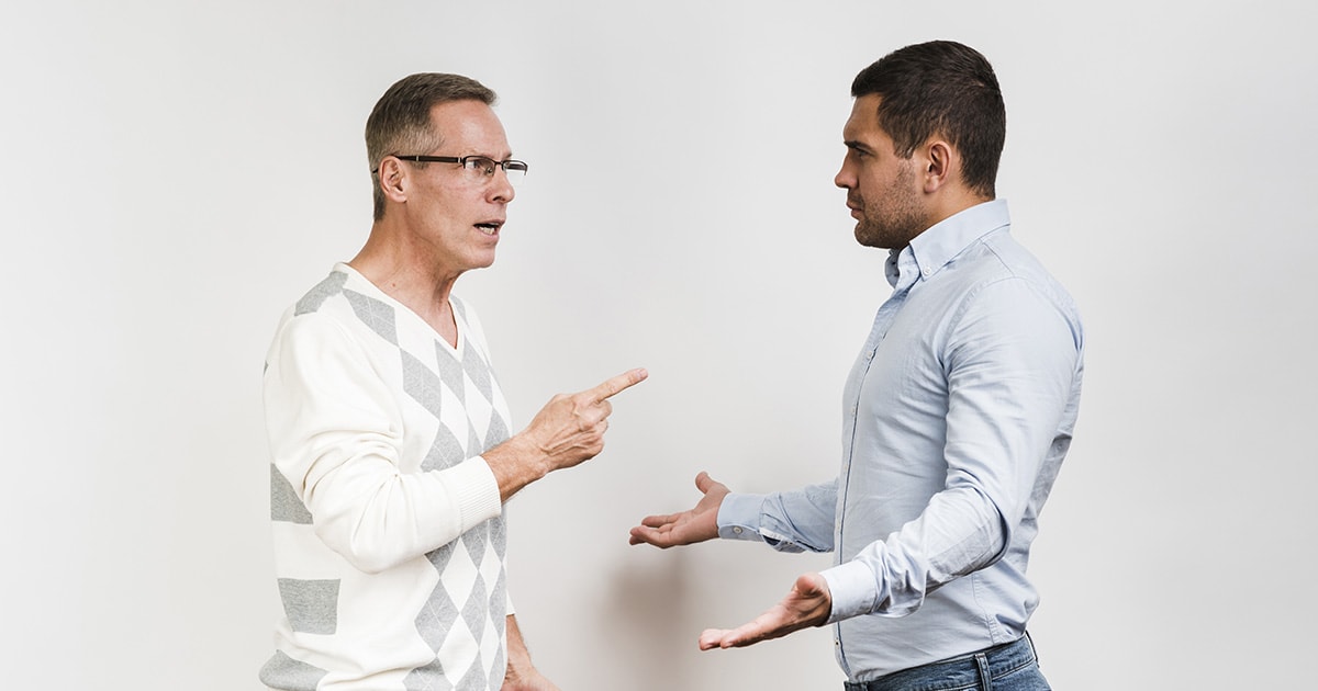 Két férfi vitázik, egyik nyugodt és kérdez, a másik erőszakos testtartásban le akarja győzni a szavaival
