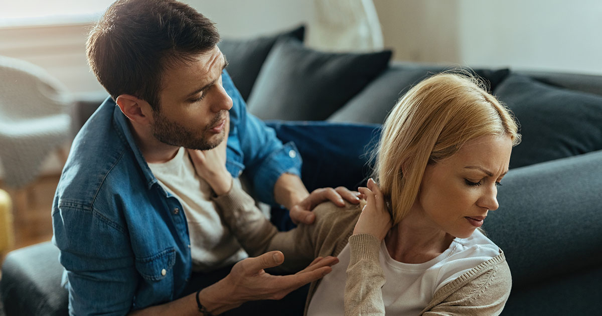 Párkapcsolati konfliktus egy férfi és egy nő között, a nő elfordul miközben a férfi beszél hozzá. A bizalom megrendülésének pillanata.