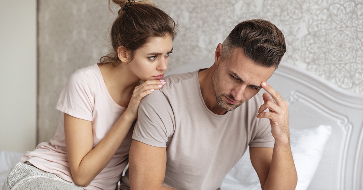 Egy nő és egy férfi ül egymás mellett beszélgetnek, a férfi szomorú, a nő átöleli és meghallgatja